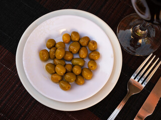 Bunch of large green olives with pits served in bowl