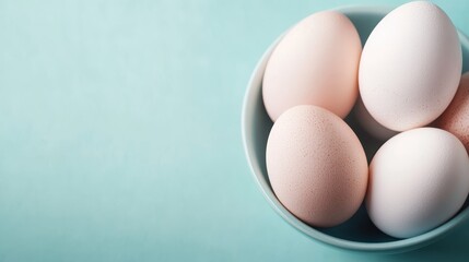 Fototapeta premium In this composition, four fresh white eggs are arranged neatly in a light blue bowl, presenting a simple yet elegant theme of natural beauty and purity.