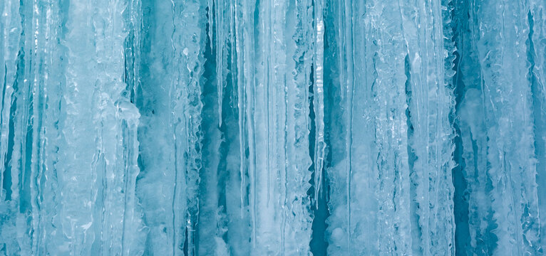Cold winter icicles melting banner. Blue frozen ice close-up photograph. 	