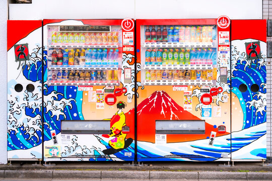 Japan, Tokyo - February 21, 2024: Two vibrant vending machines decorated with traditional Japanese art, waves, and Mount Fuji. Photo taken in Tokyo, Japan.