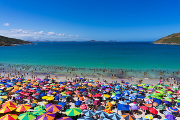 A summer day on the beach of Arraial do Cabo, Brazil. A multitude of colorful umbrellas and...