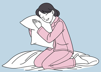 Asian woman in pink pajamas hugs a soft white pillow while sitting on a bed under a white blanket, smiling gently against a plain blue background, expressing comfort and warmth.