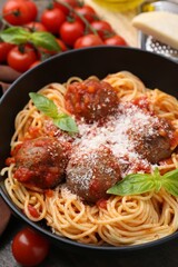 Delicious pasta with meatballs and cheese in bowl on table, closeup