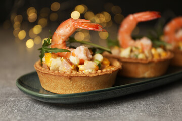Tartlets with delicious filling on grey table, closeup. Bokeh effect