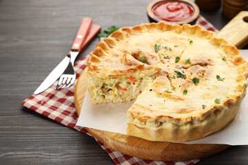 Delicious fresh homemade pie and cutlery on wooden table, closeup