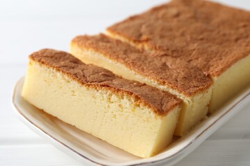 Tasty Japanese Castella sponge cake on white wooden table, closeup