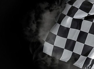 Racing flag with black and white checkers in smoke on dark background, space for text
