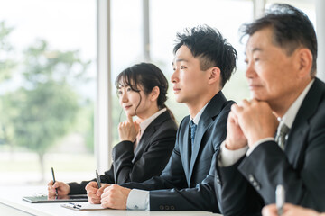 セミナーを受けるスーツ姿のシニアと若者（自己啓発・家族セミナー・介護セミナー）
