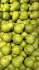 A stand of green pears arranged in a supermarket.