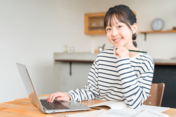 家でパソコンを使いながら勉強する小学生,中学生の女の子,子供
