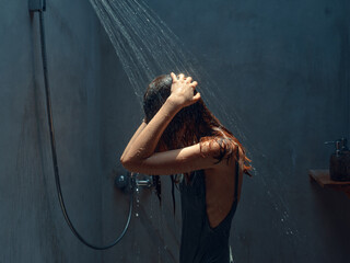 Relaxing in the moment woman standing in shower with wet hair and hands on head