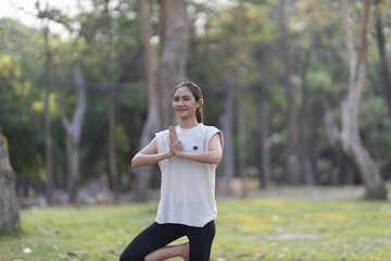 A enthusiastic Asian sports woman stopped after exercising at the garden, sitting on a exercise...