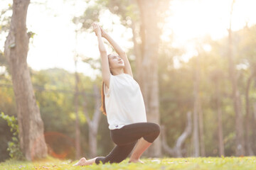 A enthusiastic Asian sports woman stopped after exercising at the garden, sitting on a exercise...
