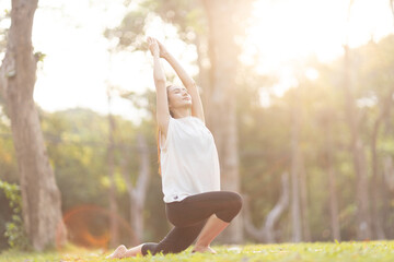 A enthusiastic Asian sports woman stopped after exercising at the garden, sitting on a exercise...