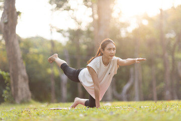 A enthusiastic Asian sports woman stopped after exercising at the garden, sitting on a exercise...