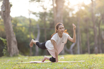 A enthusiastic Asian sports woman stopped after exercising at the garden, sitting on a exercise...