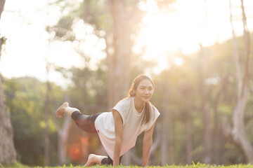A enthusiastic Asian sports woman stopped after exercising at the garden, sitting on a exercise...