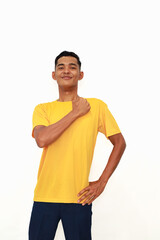 Fototapeta premium Young Asian man in yellow shirt with confident pose on white backdrop