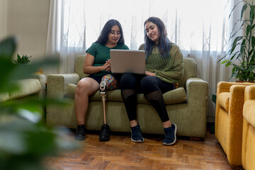 Two latin women working from home using laptop and showing inclusion and diversity