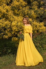 Fototapeta premium Yellow Dress Woman Spring Fashion Photography: Outdoor Portrait Mimosa Flowers