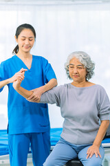 Obraz premium Elderly woman receives medical services from home care nurse while performing muscle strengthening exercises.
