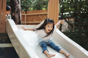  toddler girl sliding and playing at playground