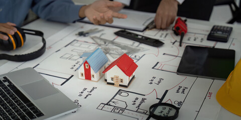 Architecture and Planning. Collaborators discussing building designs and ideas over architectural plans.