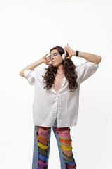 Genderless person listening to music and happy with their pride pants on a white background with copy space