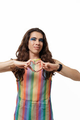 A non-gendered person poses with their fingers in a heart shape, supporting the Pride community.