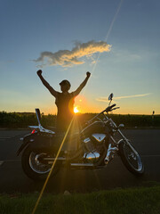 homem motoqueiro com moto custom no pôr do sol, celebração dia do motociclista 