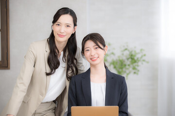 オフィスで働くビジネスウーマン複数の2人のカメラ目線