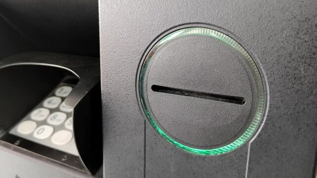 illuminated ATM machine card reader slot with visible keypad. Perfect for banking and finance concepts.