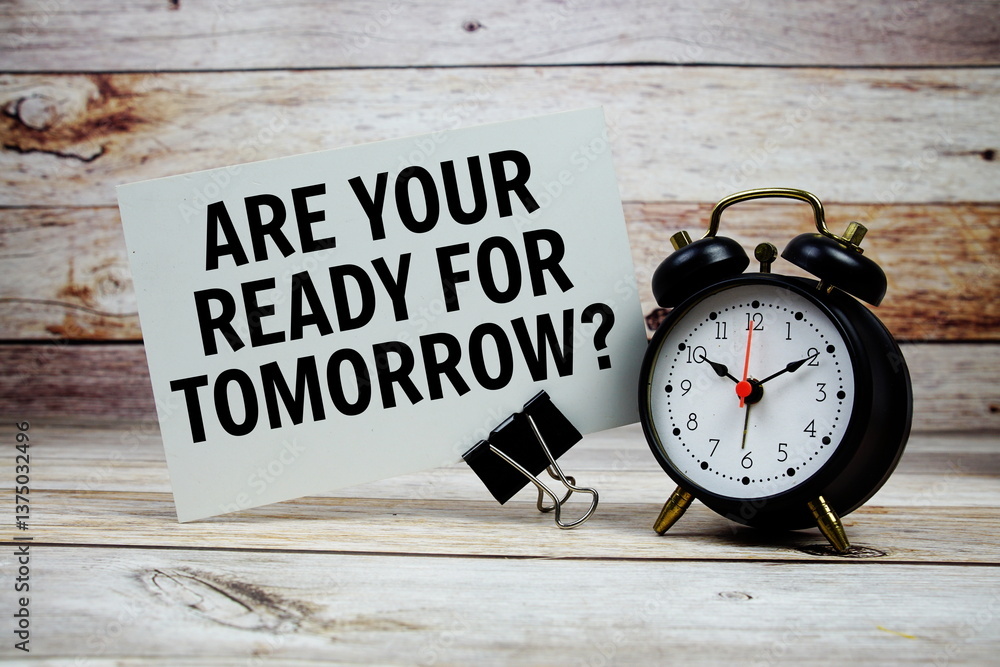 Poster are your ready for tomorrow? text on paper card with alarm clock on wooden background