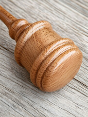 Close-up of a polished wooden gavel on a wood surface . AI generative