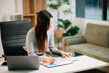 Confident Asian woman with a smile standing holding notepad and tablet