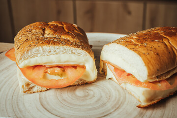 photo of sandwich split in two, with ham, tomato, cheese and pickles in a Colombian cafeteria