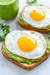 Two avocado toasts topped with fried eggs and a side of green smoothie . AI generative