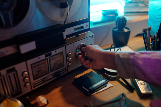 Young Man Turning on Vintage Reel-to-Reel Audio Tape Recorder