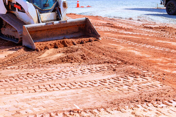 Heavy machinery is leveling ground at construction site for foundation
