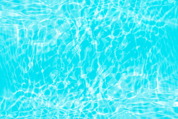 Blue water with ripples on the surface. Defocus blurred transparent blue colored clear calm water surface texture with splashes and bubbles. Water waves with shining pattern texture background.