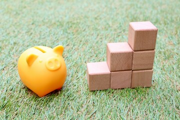 投資や貯金のイメージ　豚の貯金箱と積み立てられた積み木