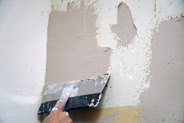 A man plastering a wall with a spatula