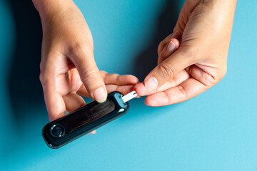 Woman's hands checking diabetes and hyperglycemia with digital blood sugar meter. Healthcare and...