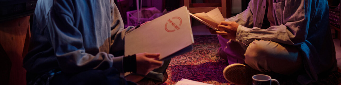 Amateur Investigators Examining Folders Labeled Top Secret and Opening Them