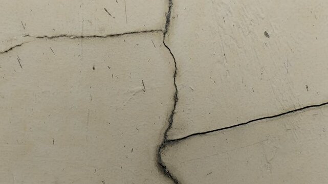 The wall is cracked. The crack is caused by extreme weather.