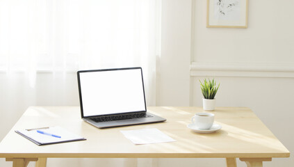 Fototapeta premium Minimalist workspace featuring a laptop on a simple wooden desk, green plant and open notebook, perfect for productivity. Isolated on white background or PNG