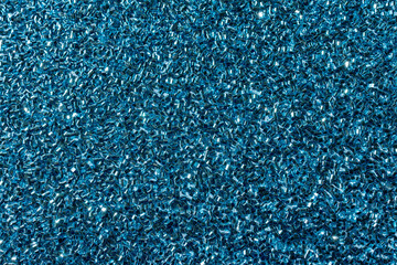 Full frame macro abstract texture background of sparkling blue color glitter surface with unique cylinder shaped glitter specks