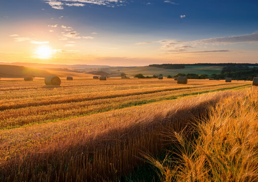 Generated image, Getreideernte, Strohballe im Feld bei Sonnenuntergang