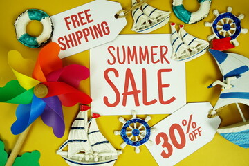 SUMMER SALE 30% OFF text on paper card with marine items decorative top view on yellow background