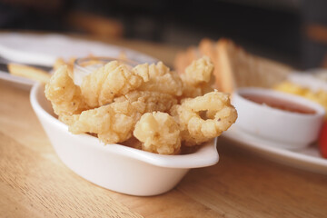 Crispy fried calamari served with dipping sauce at a casual eatery